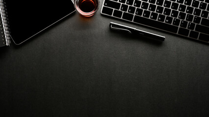 Modern black office desk top view with pc keyboard, tablet and copy space.