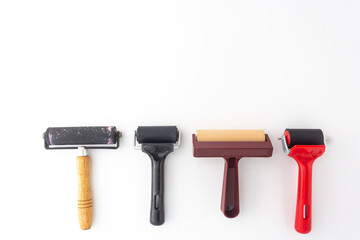 Collection of rubber brayers use in craft process on white background in top view. - obrazy, fototapety, plakaty