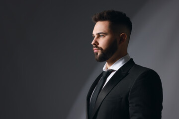 Handsome bearded man in stylish suit on grey background. Space for text