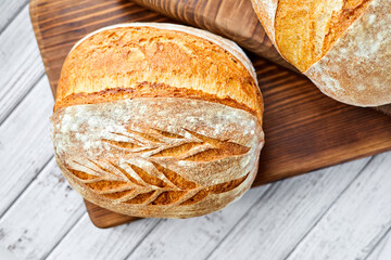 Freshly baked homemade wheat bread on a wooden background. Close-up, selective focus