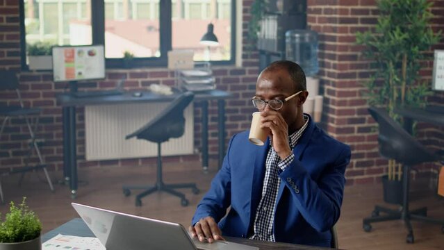 Office worker analyzing project statistics on report diagrams, planning business presentation. Company employee brainstorming ideas to send research email to manager. Handheld shot.
