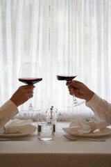 Couple with glass of red wine in a restaurant by the window