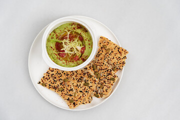 Guacamole avocado and sesame snack on white plate