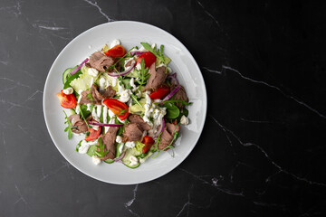 Beef tongue salad with fresh vegetables. Serving food in a restaurant. Photo for the menu