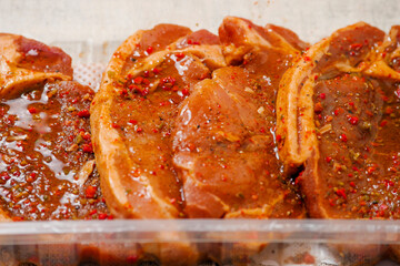 Fresh pork chops in Korean style marinade with spicy sous and herbs. Summer barbeque product in a...