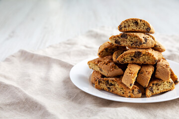 Homemade Italian Cantuccini with Chocolate on a White Plate, low angle view. Crispy Chocolate Cookies. Space for text.
