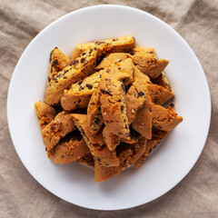 Homemade Italian Cantuccini with Chocolate on a White Plate, top view. Crispy Chocolate Cookies. Flat lay, overhead, from above.