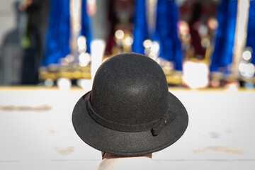 A woman in a black hat is watching a concert. Meeting.