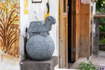 Turtle-shaped cartoon stone carving at the door of the house.  Building decoration.