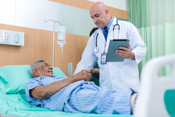 Doctor Visiting man Patient On Ward. Hospitalized man lying in bed while doctor checking his. physician examining male patient in hospital room.