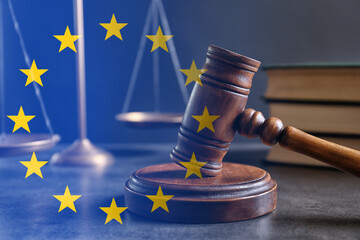 Double exposure of European union flag and judge's gavel on grey table