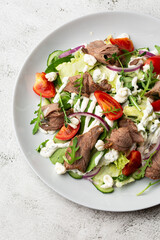Beef tongue salad with fresh vegetables. Serving food in a restaurant. Photo for the menu