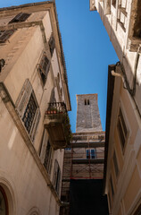 View looking up at building facades and bell tower in a narrow alley in the Diocletian's Palace in the ancient city of Split, Croatia