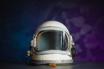 Concept of astronaut helmet on the table on the cosmic background.
