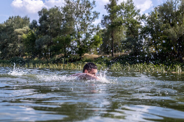 Fototapeta na wymiar The young man swimming in the river