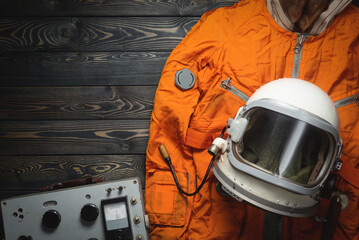 Concept of astranaut helmet and space suit on the old table flat lay background with copy space.