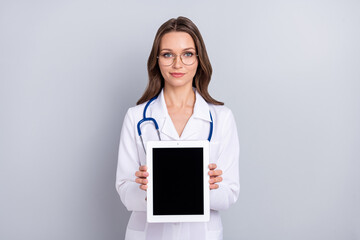 Photo of young lady pediatrician show tablet recommend therapist isolated over grey color background