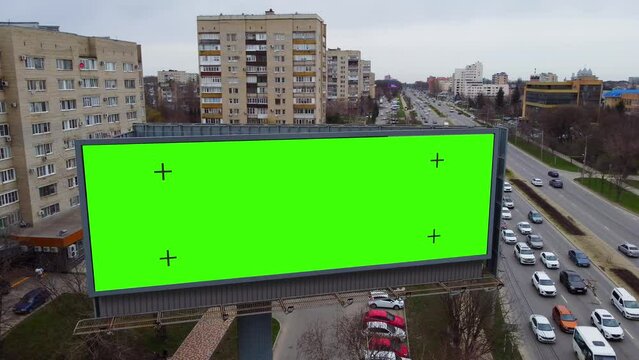 Billboard near the road with a green background to replace the picture. Marketing and advertising in the city