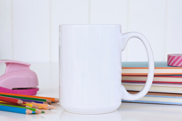 15 oz Mug mockup with workspace accessories on a white table.