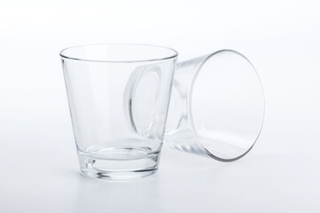 Two classic shape empty glasses on a white surface