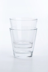 Two classic shape empty glasses on a white surface