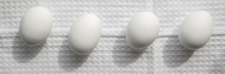 Eight white chicken eggs on a linen white cloth with folds. Easter, spring holiday concept.