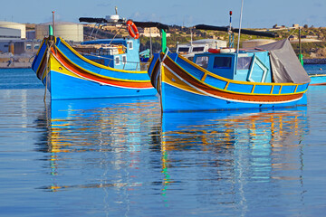Fototapeta na wymiar Traditional colourful Maltese 'Luzzu' fishing boats in Marsaxlokk bay in Malta
