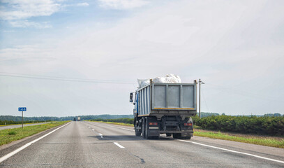 Transporting waste in a dump truck on the highway for recycling. Transportation of recyclable...