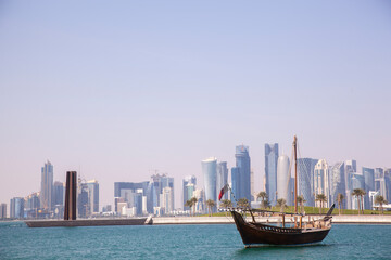 Doha,Qatar- April 24,2022 :  Traditional dhow boats with the futuristic skyline of Doha in the background.
