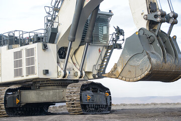 Big excavator in coal mine at cloudy day, low angle view