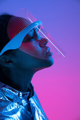 Woman in futuristic smart glasses against multi-colored background