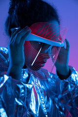 Young woman adjusting futuristic smart glasses