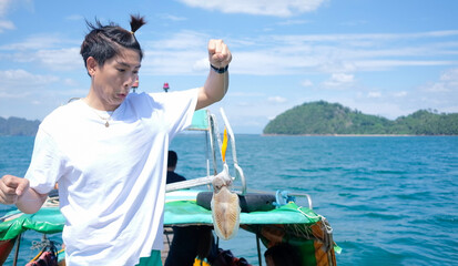 Young asian man surprise of fishing big squid in Pak meng Trang
