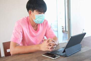 Asian man wear face mask and using tablet