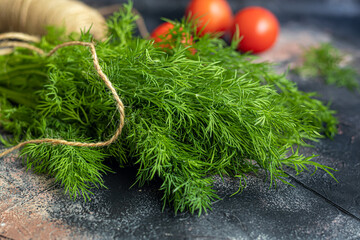Fresh vegetables for salad. Tomatoes and lettuce, cucumbers with zucchini and cabbage with dill. Spring harvest, benefits and vitamins. On a dark background.