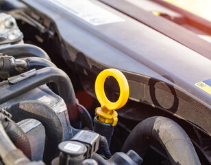 orange dipstick for checking the oil level in a diesel engine. Concept of oil viscosity and...