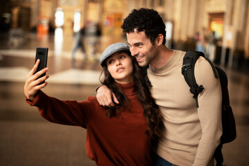 Beautiful couple at railway station waiting for the train. Young woman and man waiting to board a train...