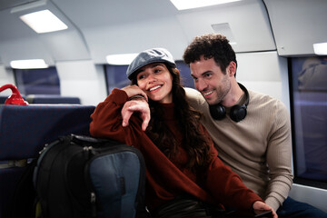 Loving couple travel by train. Happy woman and man talking while sitting in the train.
