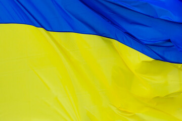 The blue yellow flag of Ukraine waving close up fragment with copy space