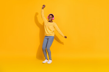 Fototapeta na wymiar Full length body size view of attractive cheerful dreamy girl fan listening rock dancing isolated over bright yellow color background