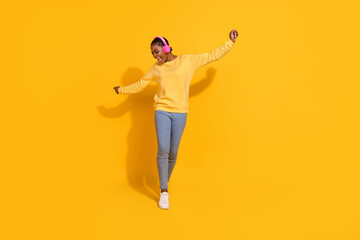 Full length body size view of attractive cheerful carefree girl listening single dancing isolated over bright yellow color background
