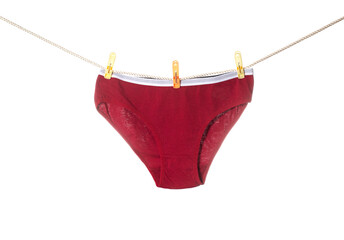 Stylish women's red panties hang on a clothesline after washing. White background, isolate - obrazy, fototapety, plakaty