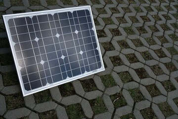 Blau-weiße Solarplatte zur Stromgewinnung steht auf Boden auf Campingplatz