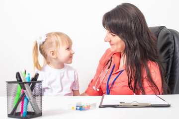 Little caucasian girl 3-4 years old at the appointment with a pediatrician. Varieties of children's doctors, children's medicine