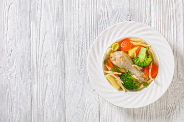 chicken vegetable soup with pasta in white bowl