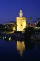 Fototapeta na wymiar Seville (Spain). Night view of the Torre del Oro next to the Guadalquivir river in the city of Seville