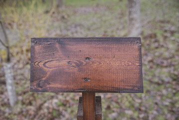 An empty wooden plaque on a blurry background.