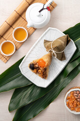 Zongzi. Rice dumpling for Dragon Boat Festival on bright wooden table background with ingredient.