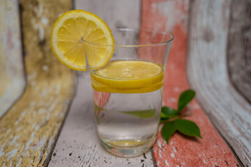 verre d'eau avec des tranche de citron avec feuilles de citronnier détox