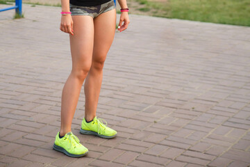 cropped image of female legs. Woman athlete stands in shorts and sneakers © Alexandra Selivanova